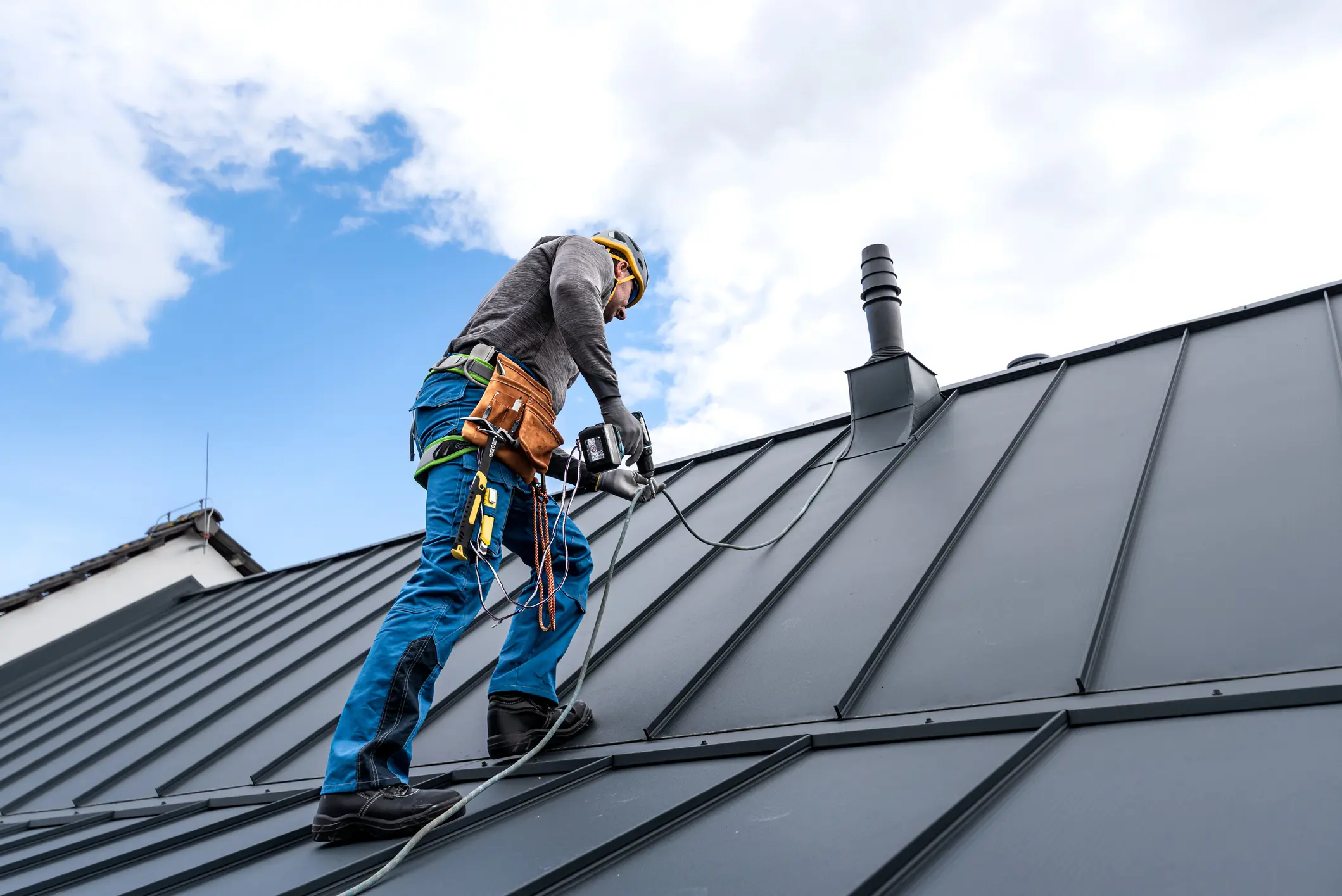 Worker installing roof with safety gear