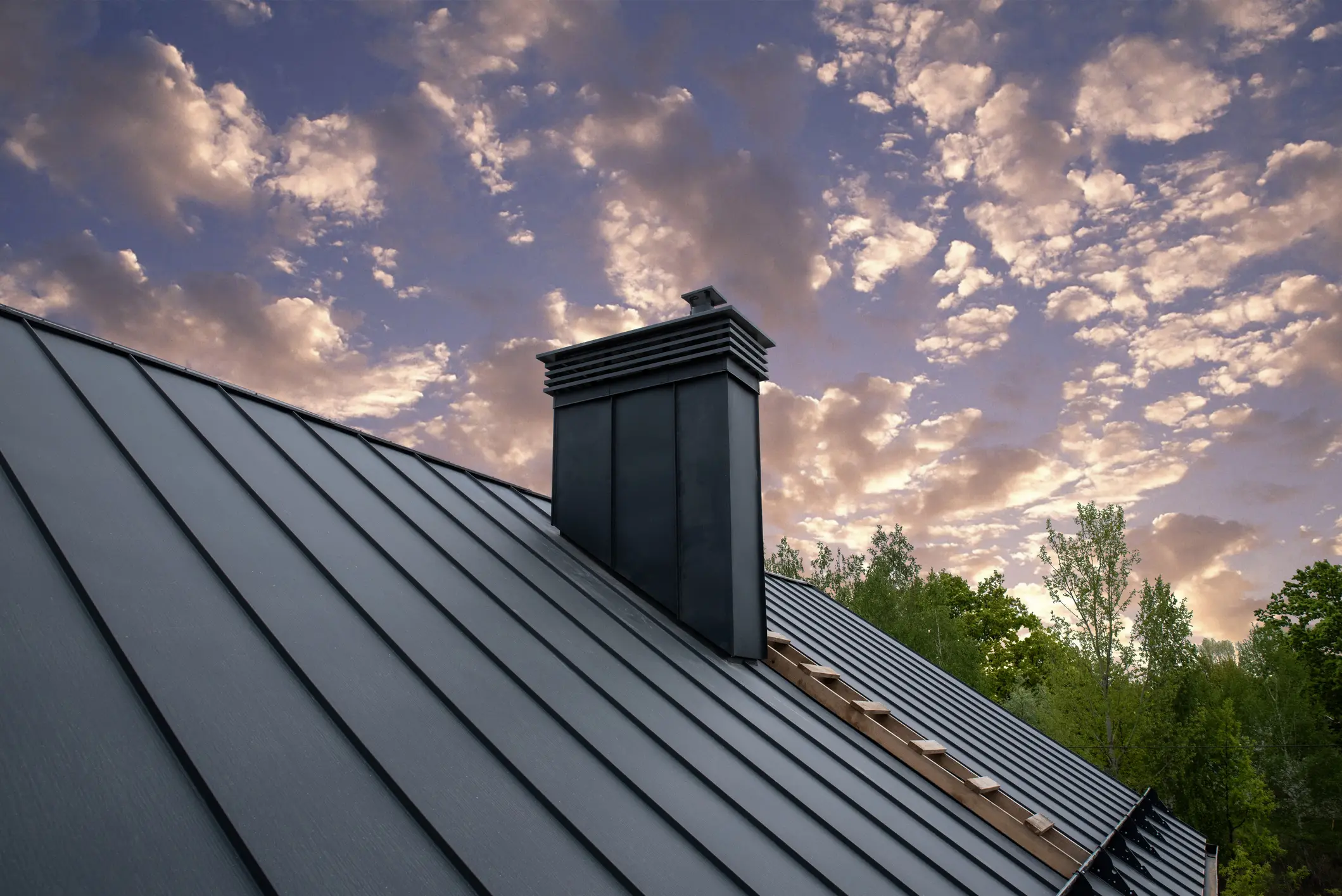 Metal roof with chimney at sunset