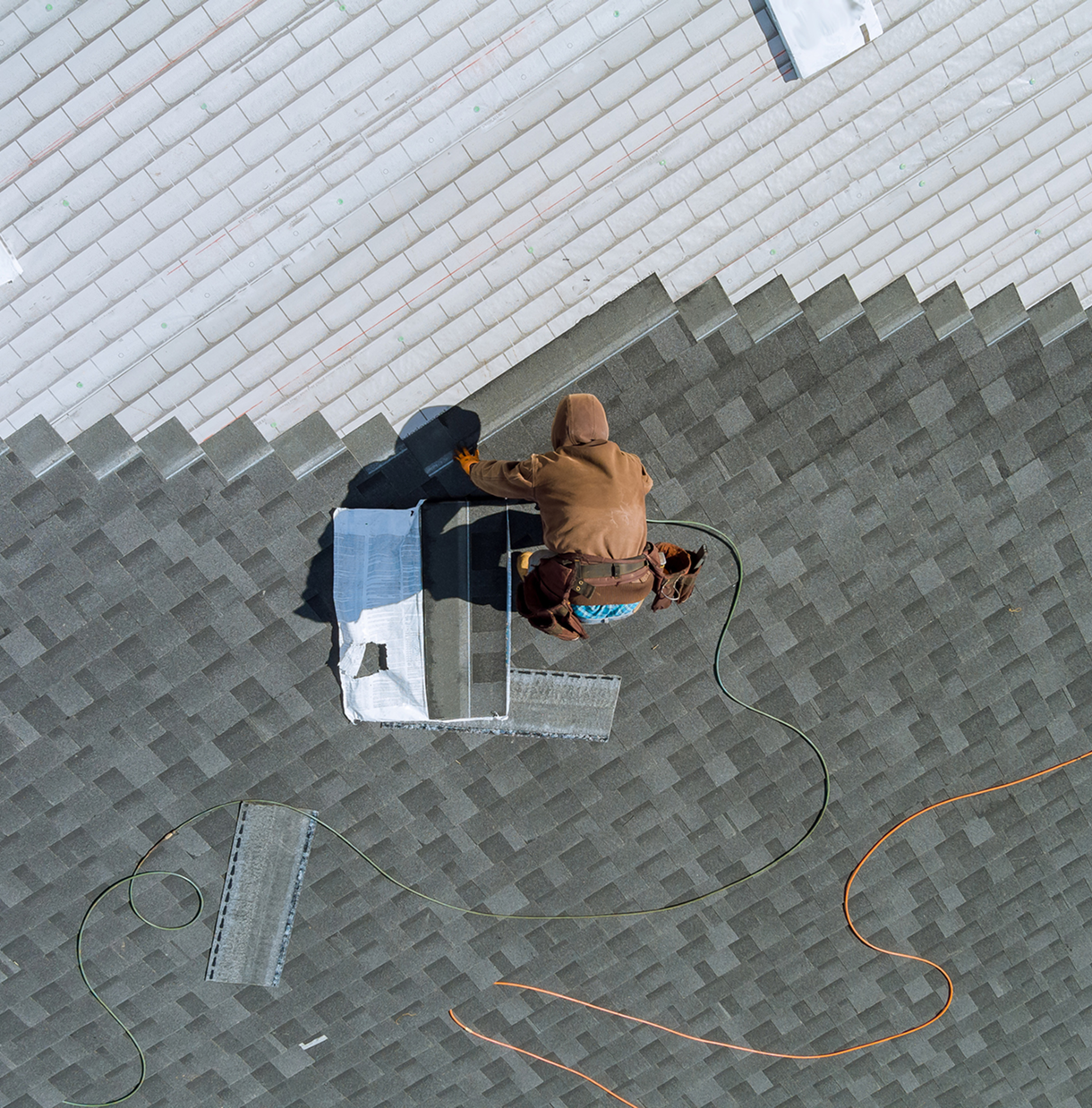 Worker repairing roof shingles