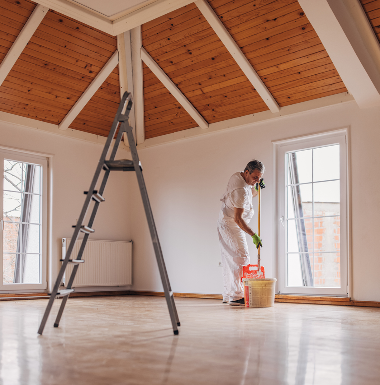 Person painting a room with ladder nearby