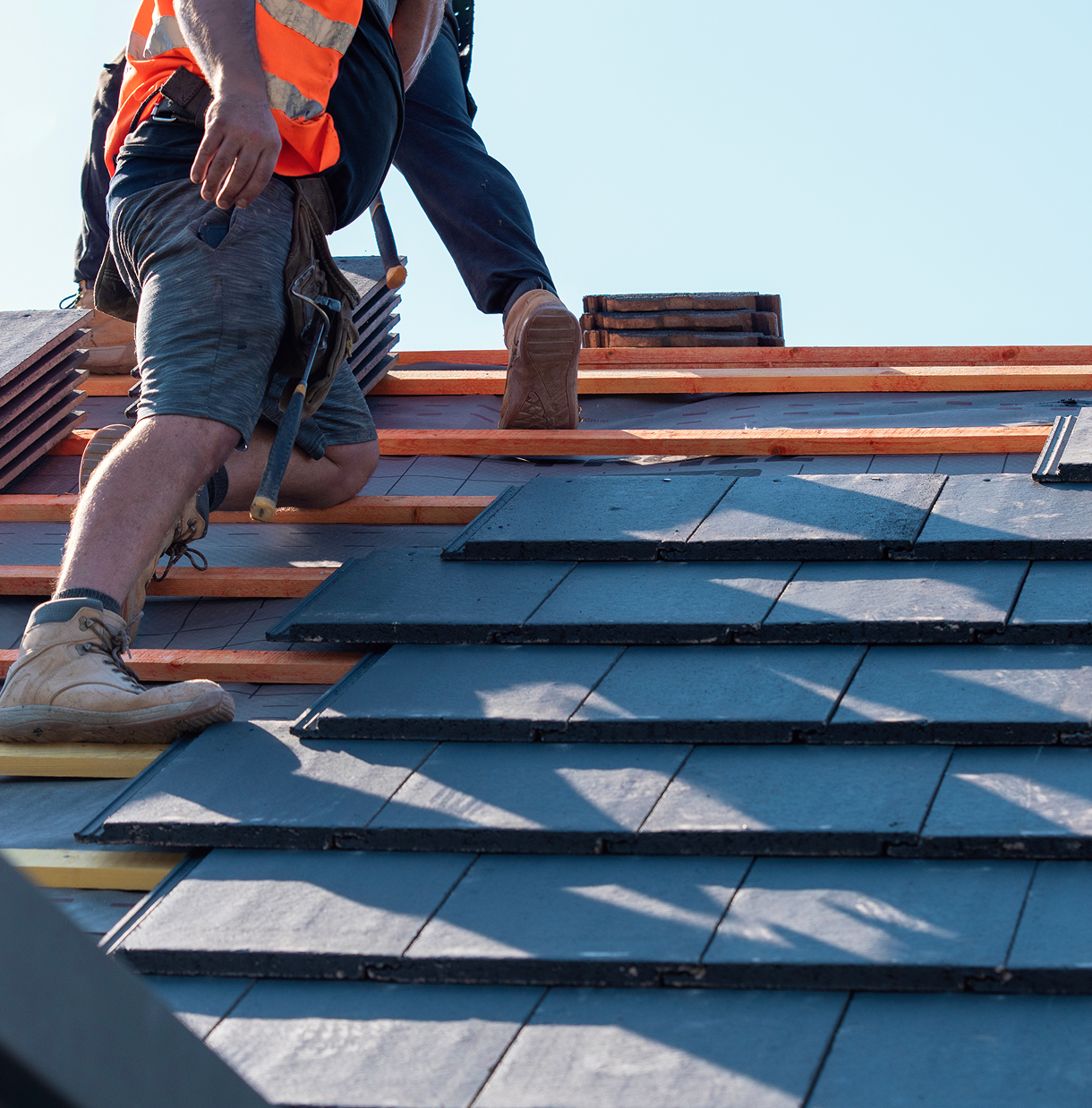 Roofers installing shingles on a house