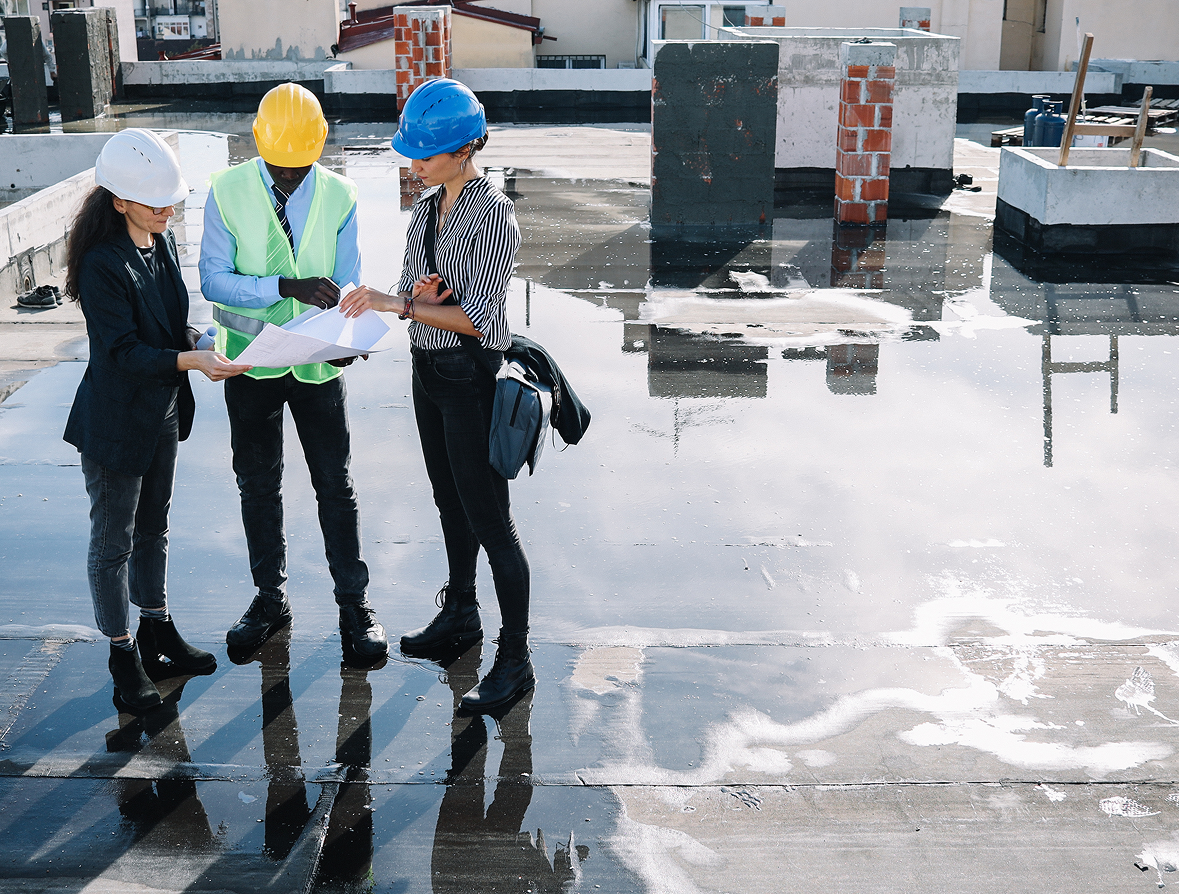 Team in helmets examining building plans